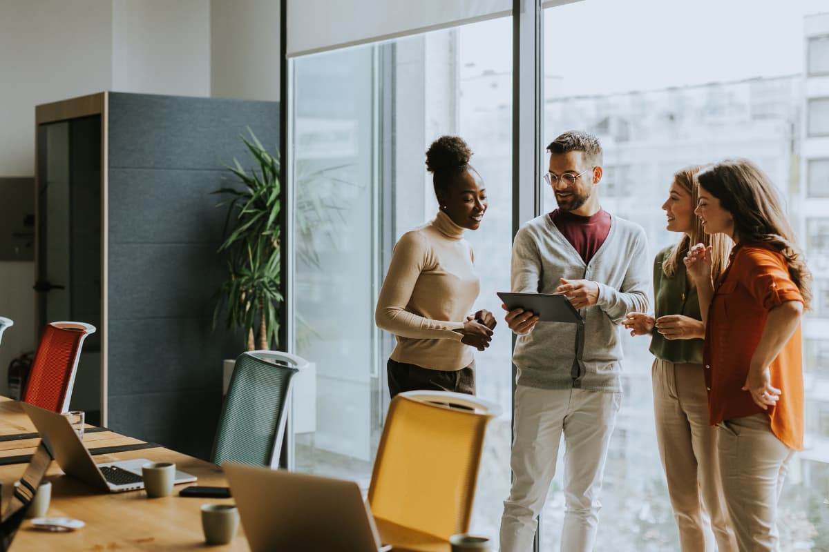 Équipe RH en discussion dans un bureau lumineux, illustrant la collaboration autour de la mise en place d’un SIRH commun dans un contexte international.