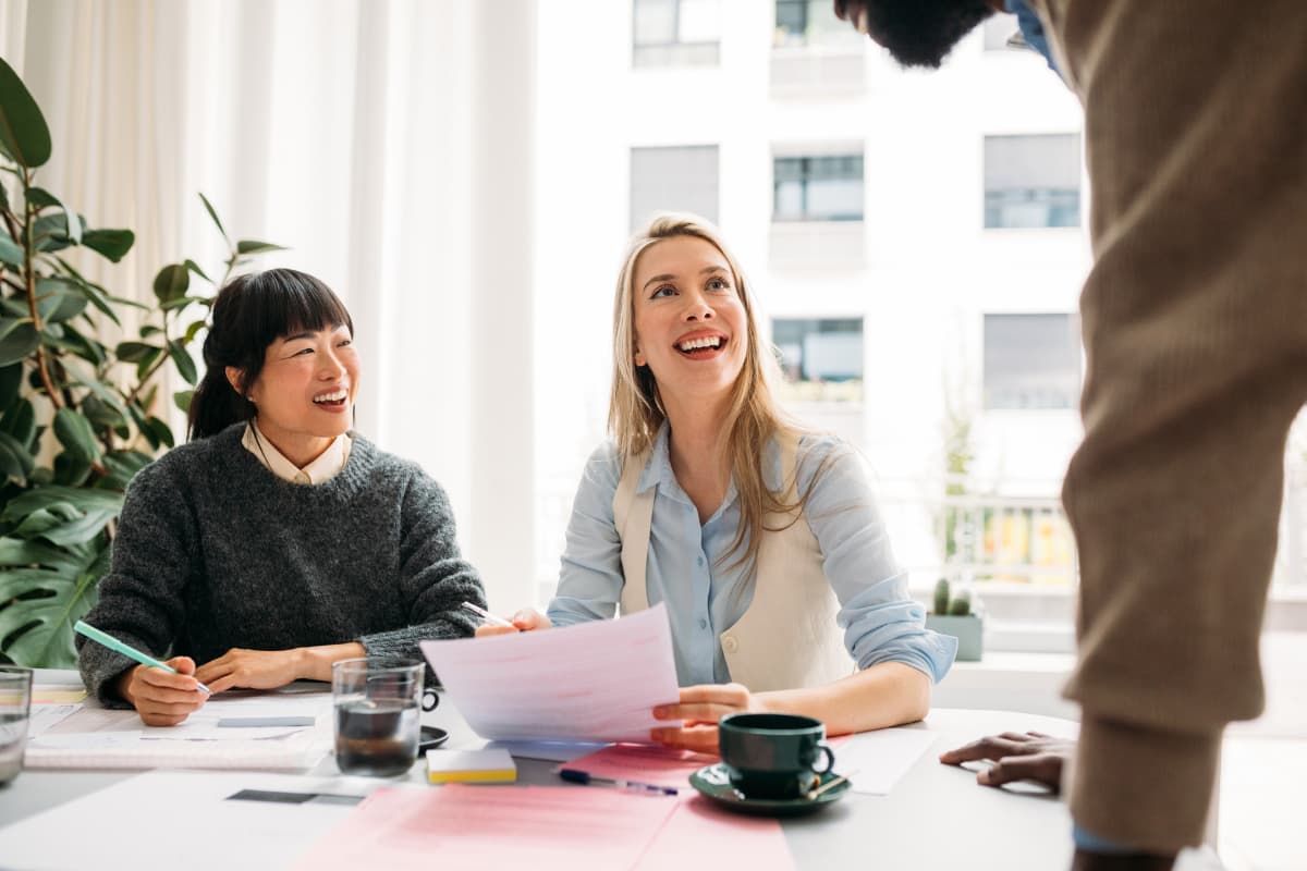 Équipe RH et finance analysant des documents de paie et de déclarations sociales en réunion de travail