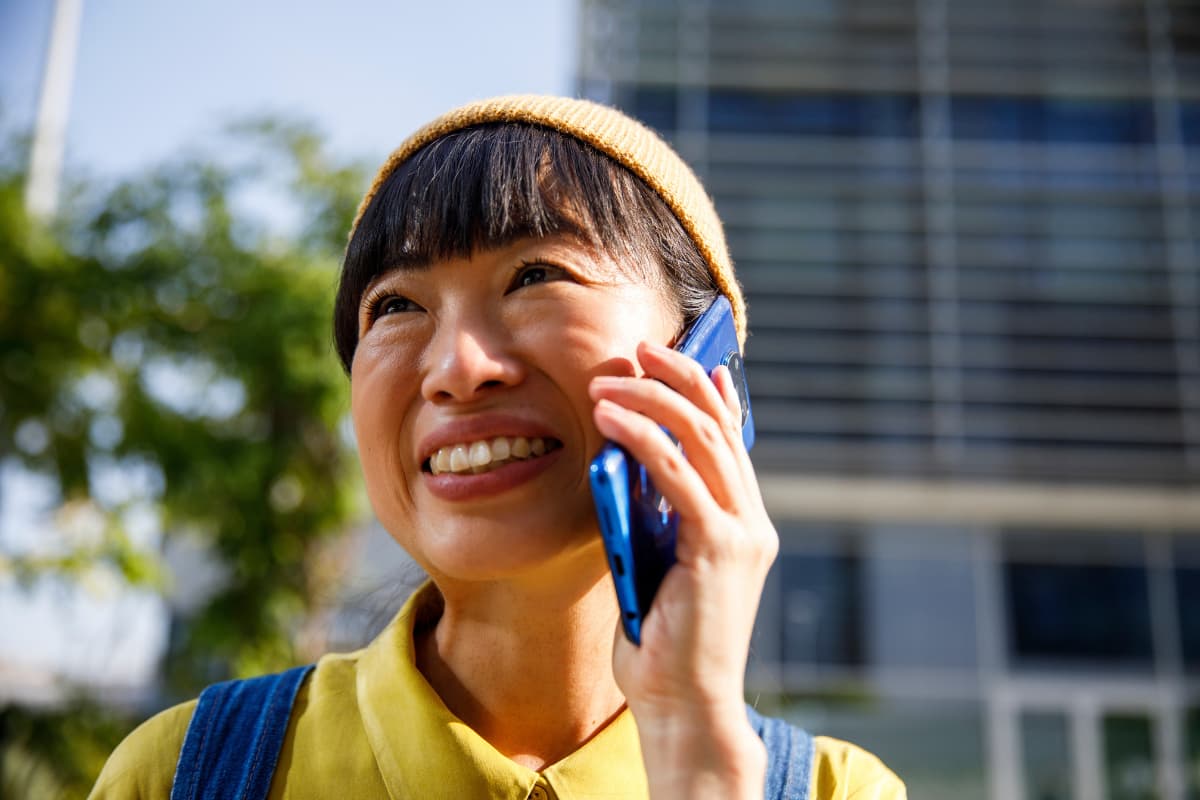Collaborateur échangeant par téléphone à l’extérieur d’un bâtiment de bureaux, illustrant les enjeux de santé mentale au travail