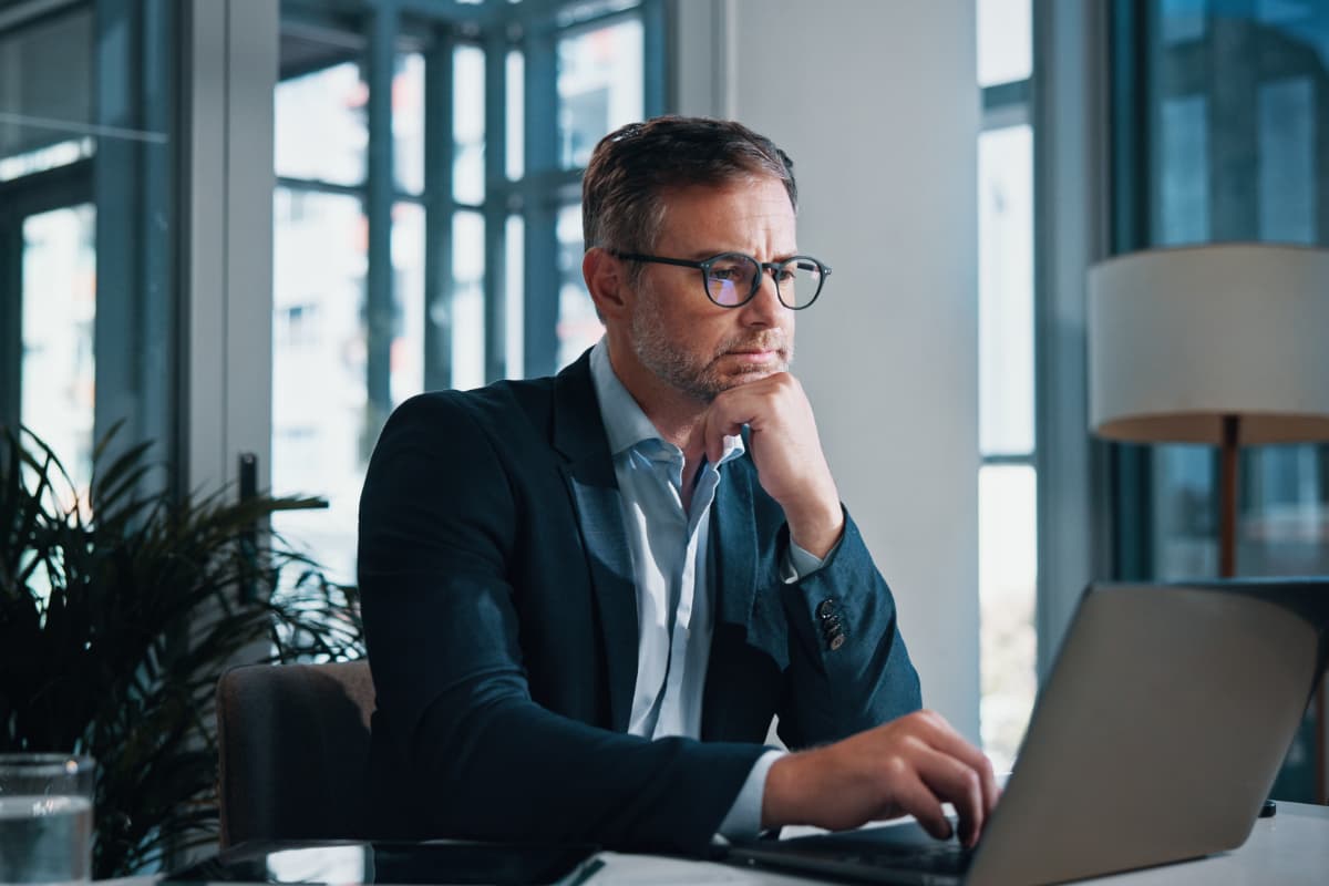 Responsable RH travaillant sur ordinateur pour piloter la gestion de la paie et évaluer une solution de paie externalisée.