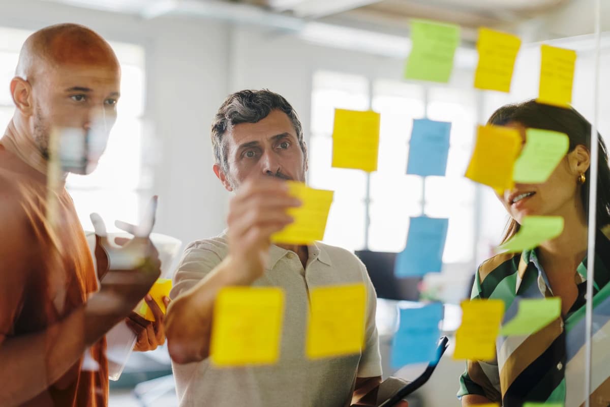 Atelier collaboratif autour d'un mur de post-it pour structurer un plan d'action en entreprise.